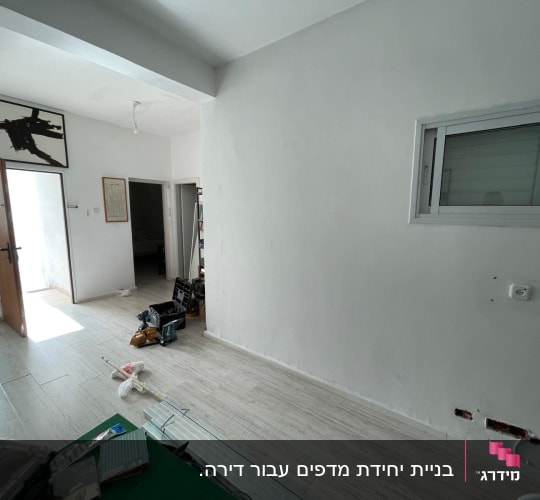 קיר גבס עם חורים ותיקונים, כלים על הרצפה